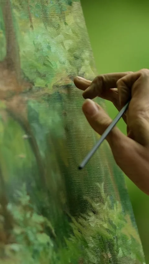 Vertical of Close-up of an artist's hand with a brush doing the blurring touches Stock Footage 276926768