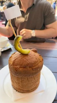 Vertical close-up of baked bread bun with pickle and blank white flag on sk.. Stock Photos