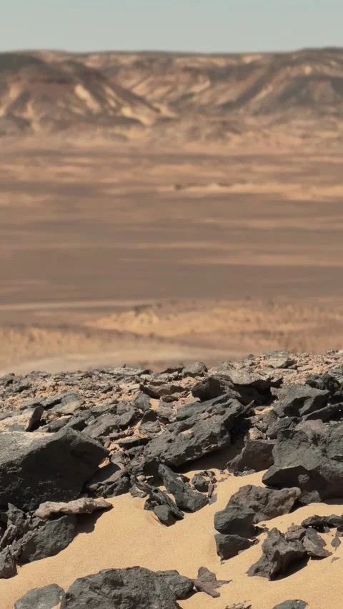 Vertical close up of black basalt rocks in arid desert landscape of Black desert Stock Footage 340868680