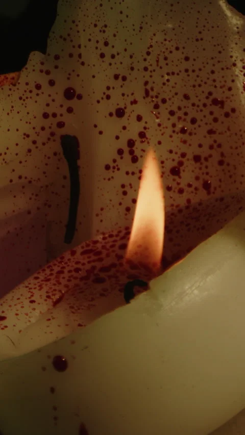 Vertical close up of a blood covered candle with burning flames. Blood gets Video stock 336321075