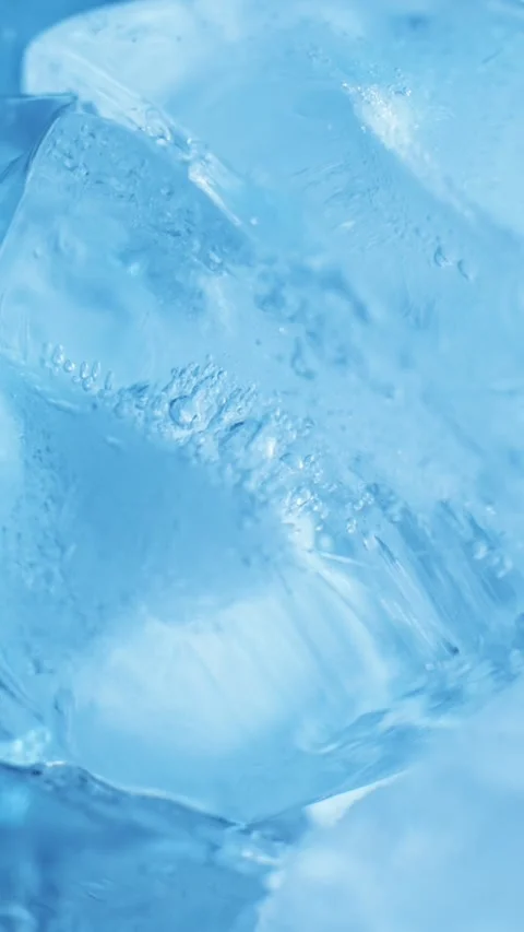 Vertical close up of blue ice cubes drifting sideways for drink cooling, re.. Stock Footage 344056487