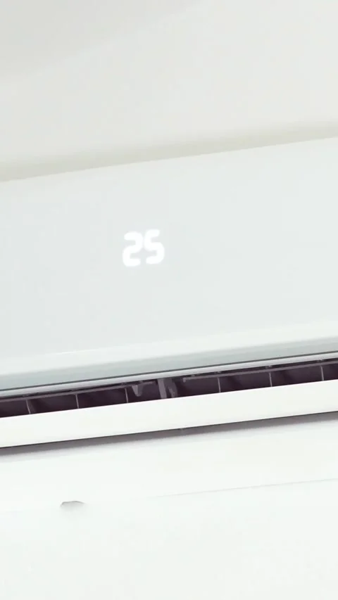 Vertical Close up of blurred hand with the remote control turns on the white air Stock Footage 312586722