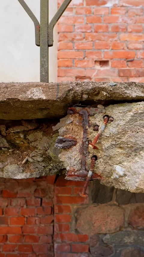 Vertical close-up of broken concrete with exposed rusted rebar on an old Stockbeeldmateriaal 333651323