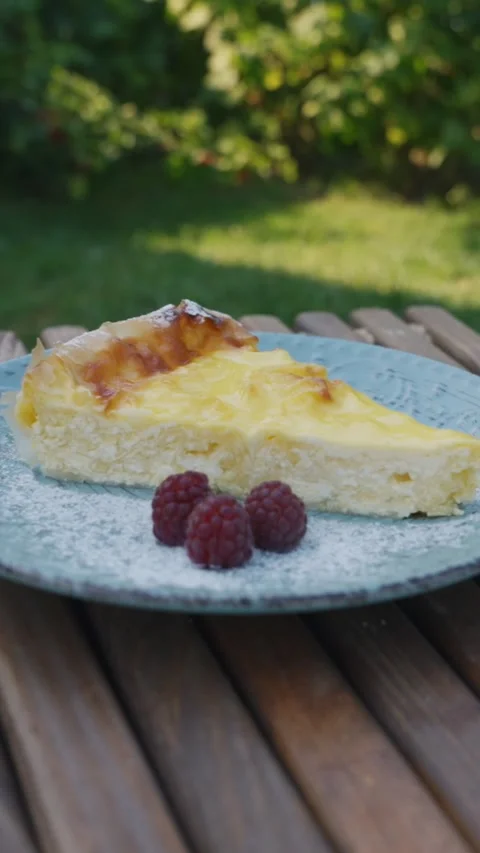Vertical Close-Up of Cheesecake Slice with Raspberries Outdoors – Mobile Food Stock Footage 339920041