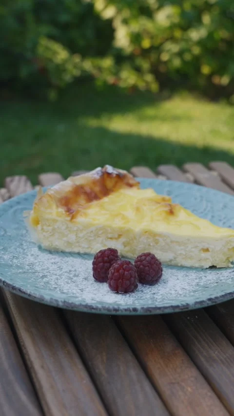 Vertical Close-Up of Cheesecake Slice with Raspberries Outdoors – Food Vertical Stock Footage 340001760