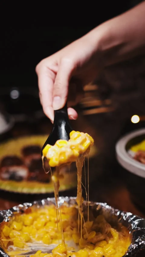Vertical close up of cheesy corn side dish served in foil at Asian restaurant 스톡 동영상 333879325