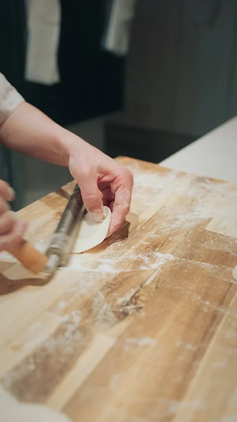 Vertical close-up of chef shaping dough balls on a floured wooden board Stock-Footage 333897559