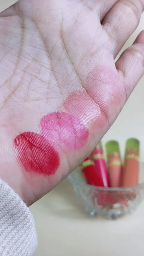 Vertical close up of cotton pad wiping colorful lipstick stains from hand. .. Stock Footage 340329364