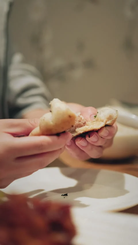 Vertical close-up of cupped hands holding a small pan-fried Chinese bun Video stock 333898517