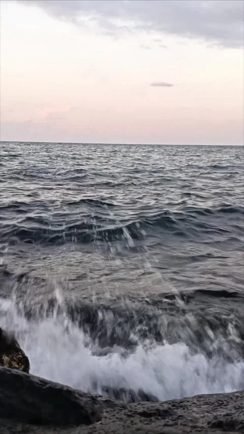 Vertical Close Up of Dark Sea Waves Crashing on Rocks at Dusk Stock Footage 342770072