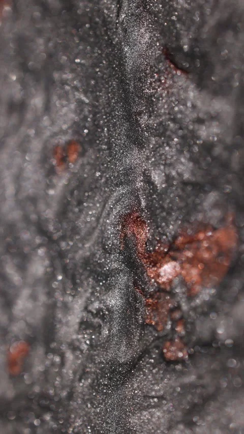 Vertical close-up of dark titanium paint mixed with a copper spot flowing slowly Stock Footage 327603471