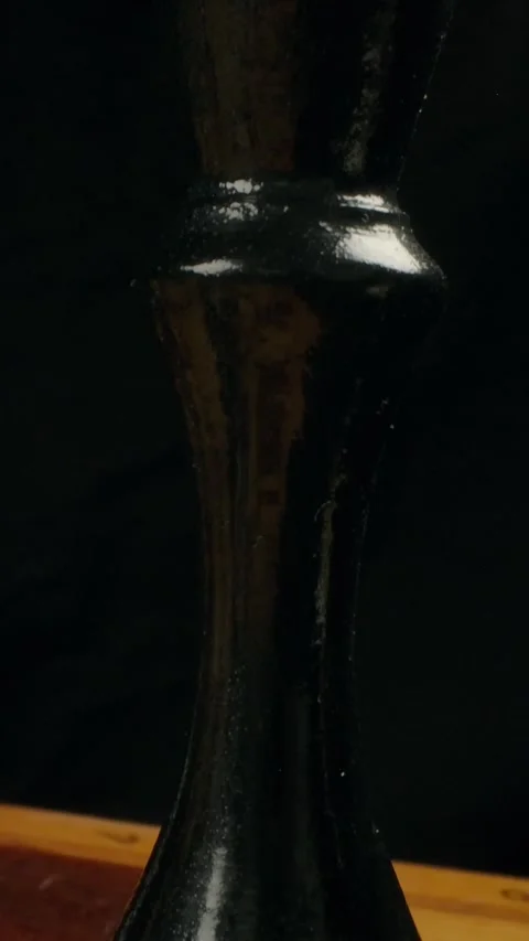 Vertical of Close-up dolly macro shot of a black wooden chess King on a Stock Footage 276926584