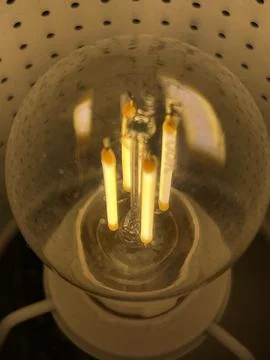 Vertical close up of edison style retro lightbulb glowing Stock Photos