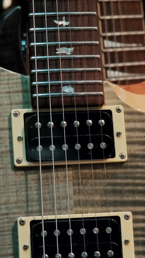 Vertical close up of electric guitar strings and black magnetic pickup Stock Footage 334633487