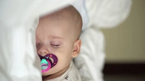 Vertical close-up face newborn chubby sleeping baby lying on stomach open eyes Stock Footage 172169720