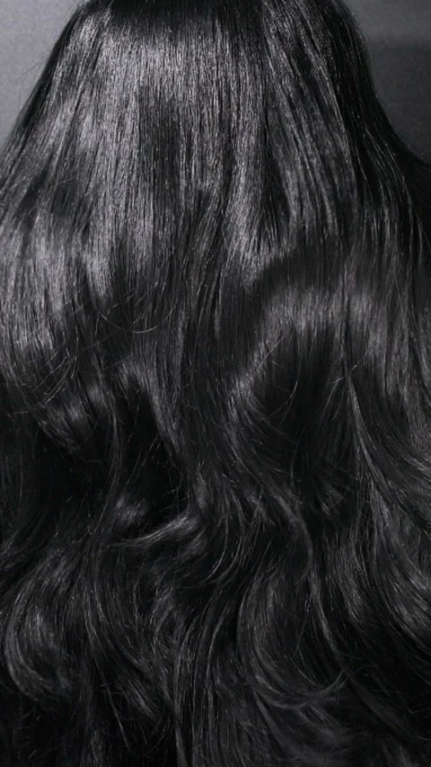 Vertical close-up of female model long black curly hair texture in slow motion Stock Footage 291614005