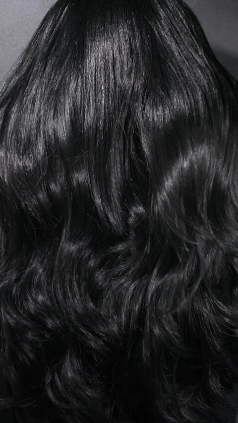Vertical close-up of female model long black curly hair texture in slow motion Stock Footage 293666752