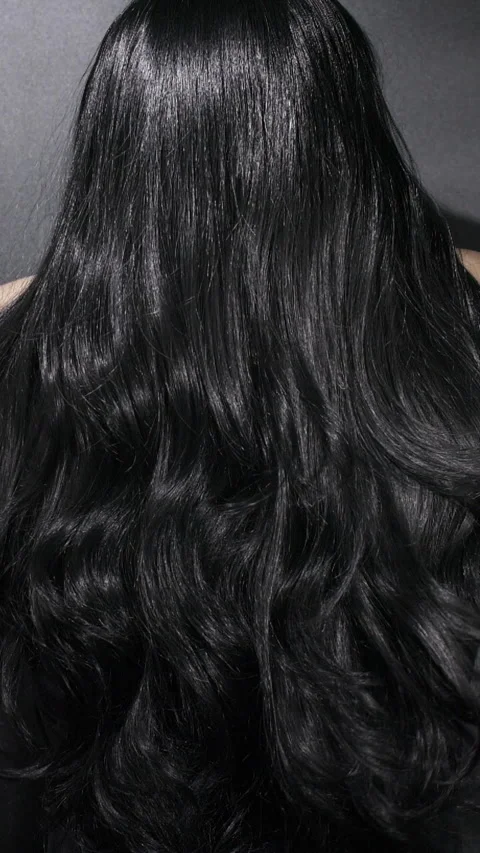 Vertical close-up of female model long black curly hair texture in slow motion Stock Footage 295249103