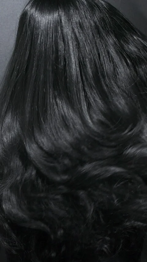 Vertical close-up of female model long black curly hair texture in slow motion Stock Footage 315202605