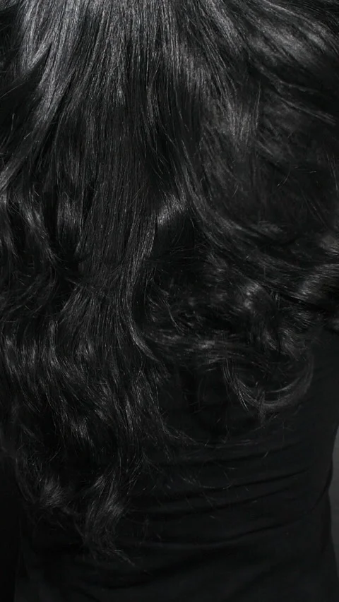 Vertical close-up of female model long black curly hair texture in slow motion Stock Footage 316282279