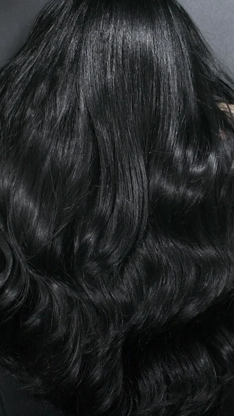 Vertical close-up of female model long black curly hair texture in slow motion Stock Footage 318205596