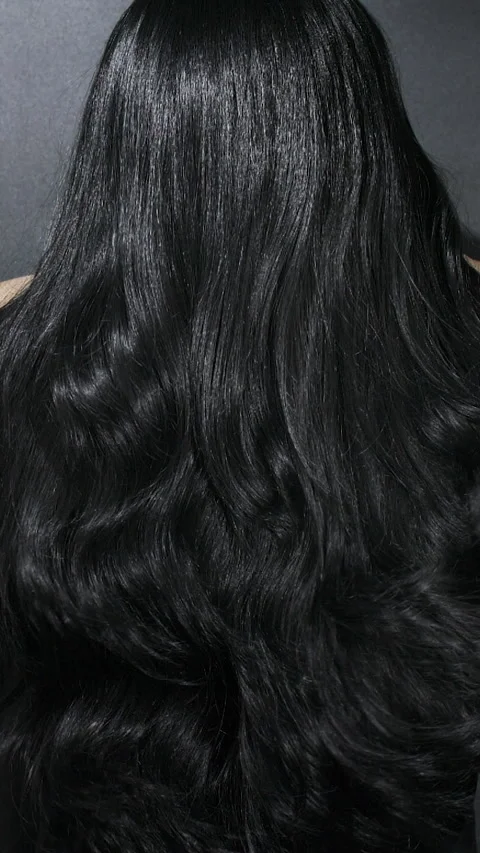 Vertical close-up of female model long black curly hair texture in slow motion Stock Footage 319058229