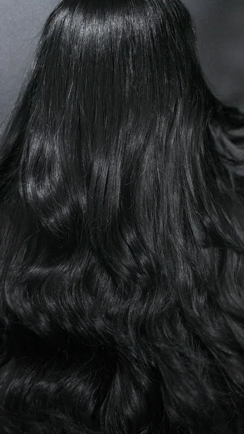 Vertical close-up of female model long black curly hair texture in slow motion Stock Footage 321855375