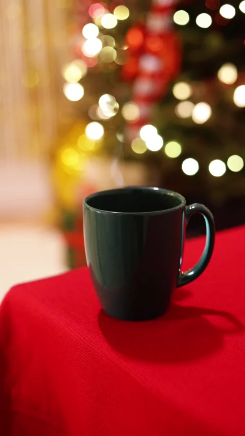 A Vertical Close Up Of A Festive Green Mug with Steam on Holiday Table Stock Footage 313706330