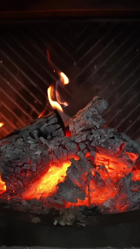Vertical close-up of flames and glowing coals in a home fireplace, hot ash and Video stock 327892197