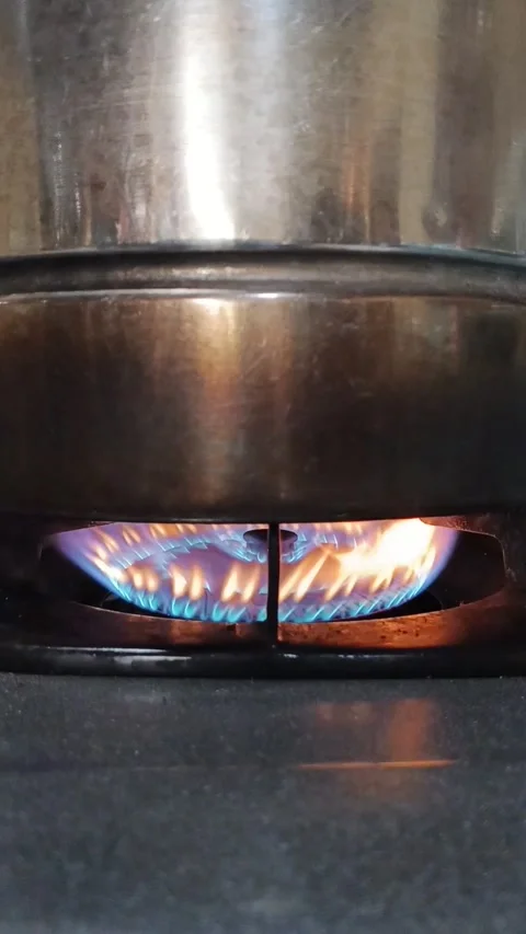 Vertical close-up of gas stove burner producing steady blue and orange flame Stock Footage 344958043
