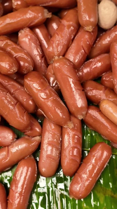Vertical Close-Up of Glossy Mini Sausages Stock Footage 326464604