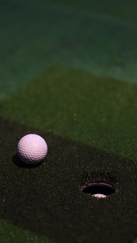 Vertical Close Up of Golf Ball Rolling Into Putting Hole Stock Footage 325691827