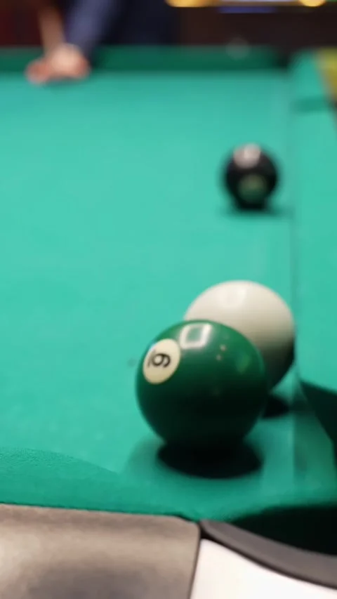 Vertical close-up of a green 6-ball rolling toward a corner pocket on a Stock Footage 328850978
