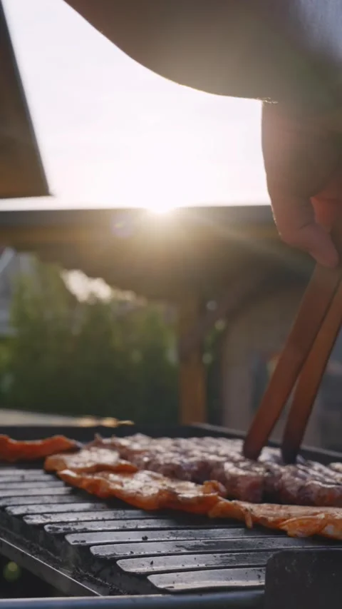 Vertical Close-Up of Grilling Meat at Backyard BBQ in Warm Sunset Light Stock Footage 339914194