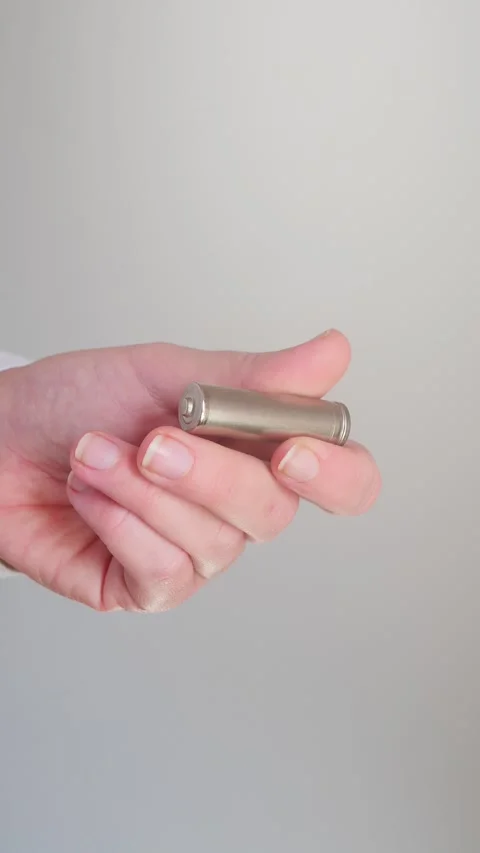 Vertical close up of hand holding AA batteries Stock Footage 328237562