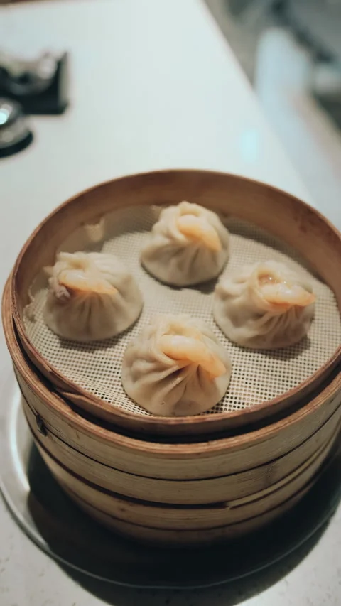 Vertical close-up of hand opening a bamboo steamer lid in a Chinese kitchen Stock Footage 333897130