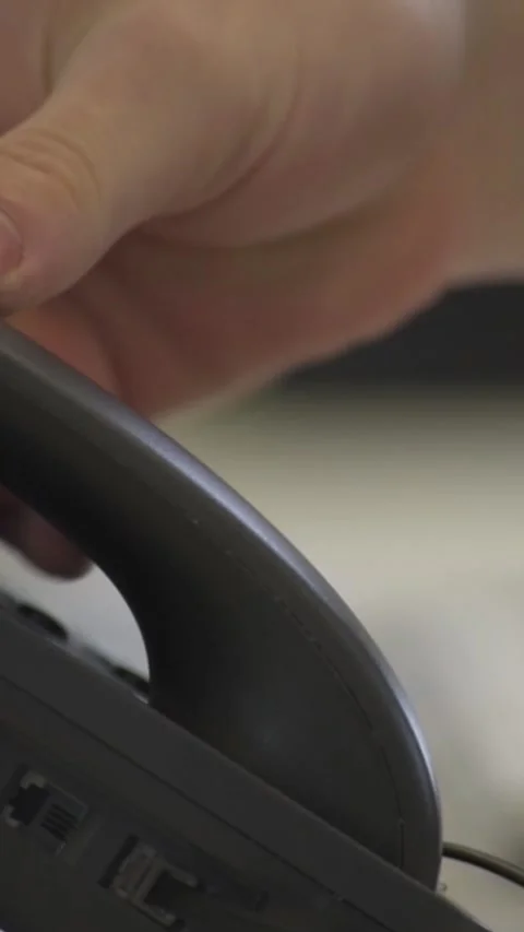 Vertical Close-Up of Hand Reaching to Pick Up Phone Handset in Office Setting Stock Footage 282666171