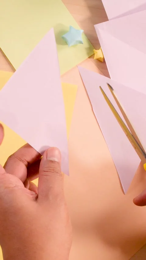 Vertical Close Up of Hands Cutting Pastel Paper for Origami Craft Stock Footage 329740899