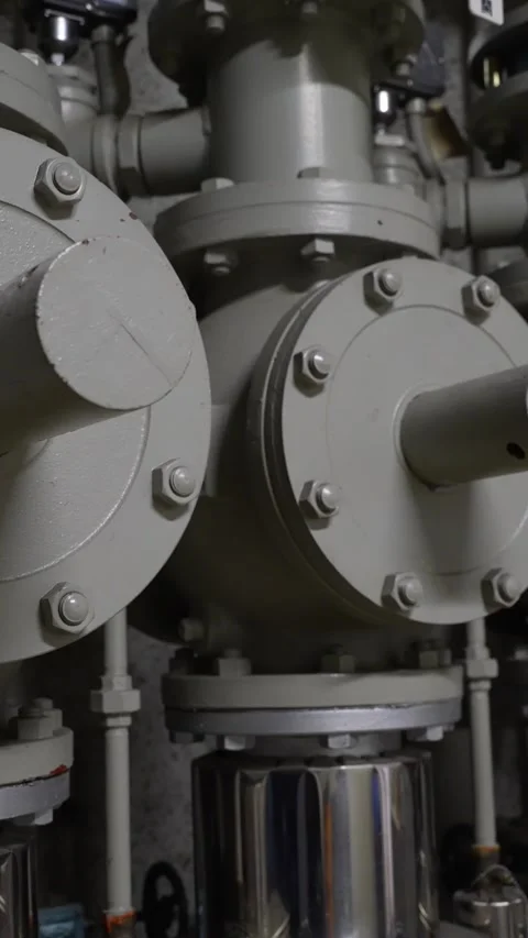 Vertical close-up of heavy industrial grey pipes and valves Stock Footage 346346863