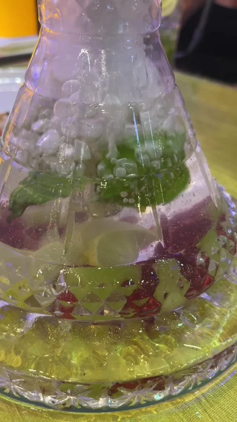 Vertical close up of hookah water base bubbling with mint and ice in lounge Видео 343156054