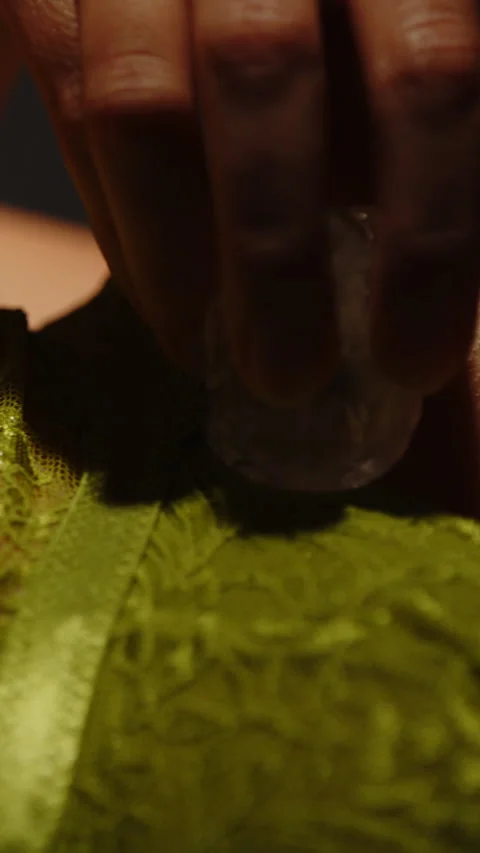 Vertical close up of an ice cube sensually stroking the body of an attractive Video stock 329211863