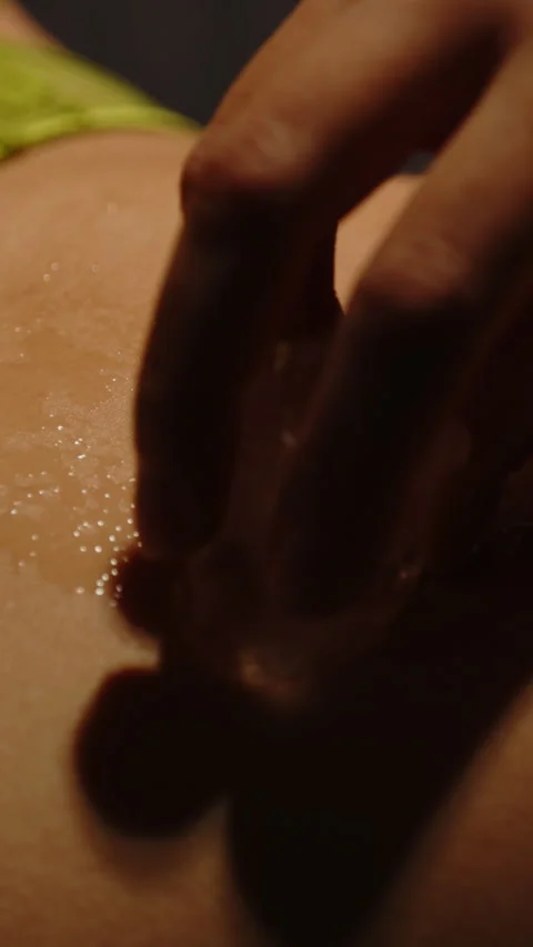 Vertical close up of an ice cube teasingly stroking the belly of a pretty woman 動画素材 329211909