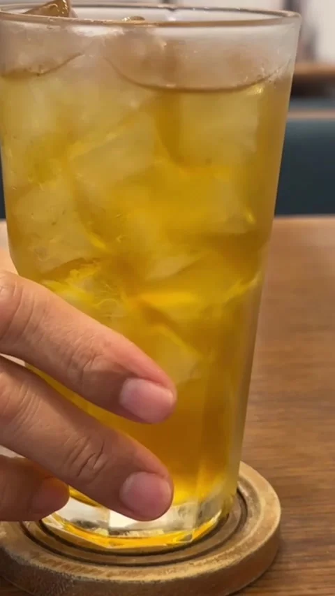 Vertical close up of iced Assam black tea in glass with ice cubes Stock Footage 316813117
