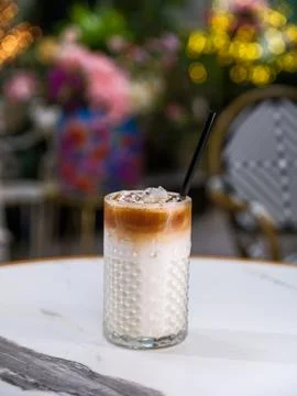 Vertical close-up of an iced latte coffee on a marble table 스톡 사진