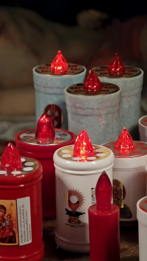 Vertical close-up of LED electric red candles decorated with religious images. Stock Footage 329257286
