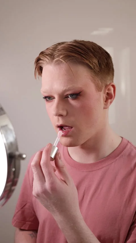 A Vertical Close-up of a Man Applying Lip Gloss in Front of Mirror Stock Footage 310223514