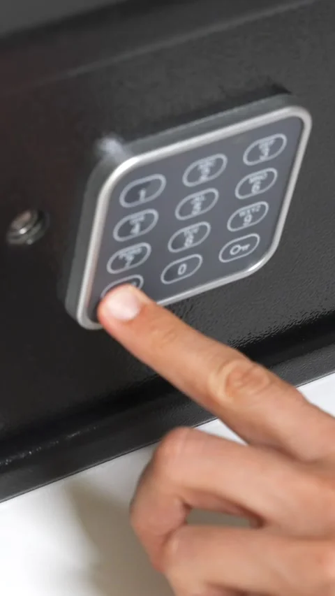 Vertical close up of a man hand open a digital combination lock of a black steel Stock Footage 312586747