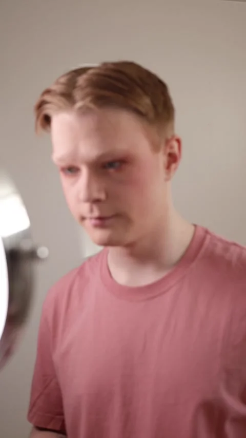 A Vertical Close-Up of a Man Removing Makeup with Wipe in Front of Mirror Stock Footage 310162294