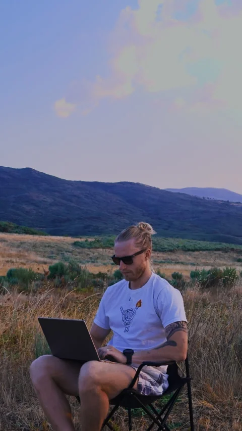 Vertical Close Up of Man in Sunglasses Typing on Laptop Vídeos de archivo 345717013