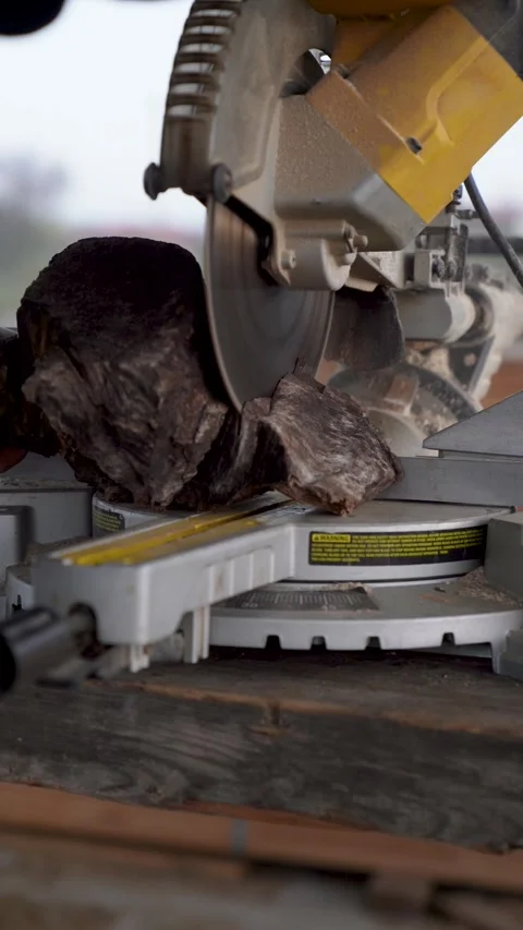 Vertical close up of a miter saw cutting a raw wooden log Stock Footage 325206434